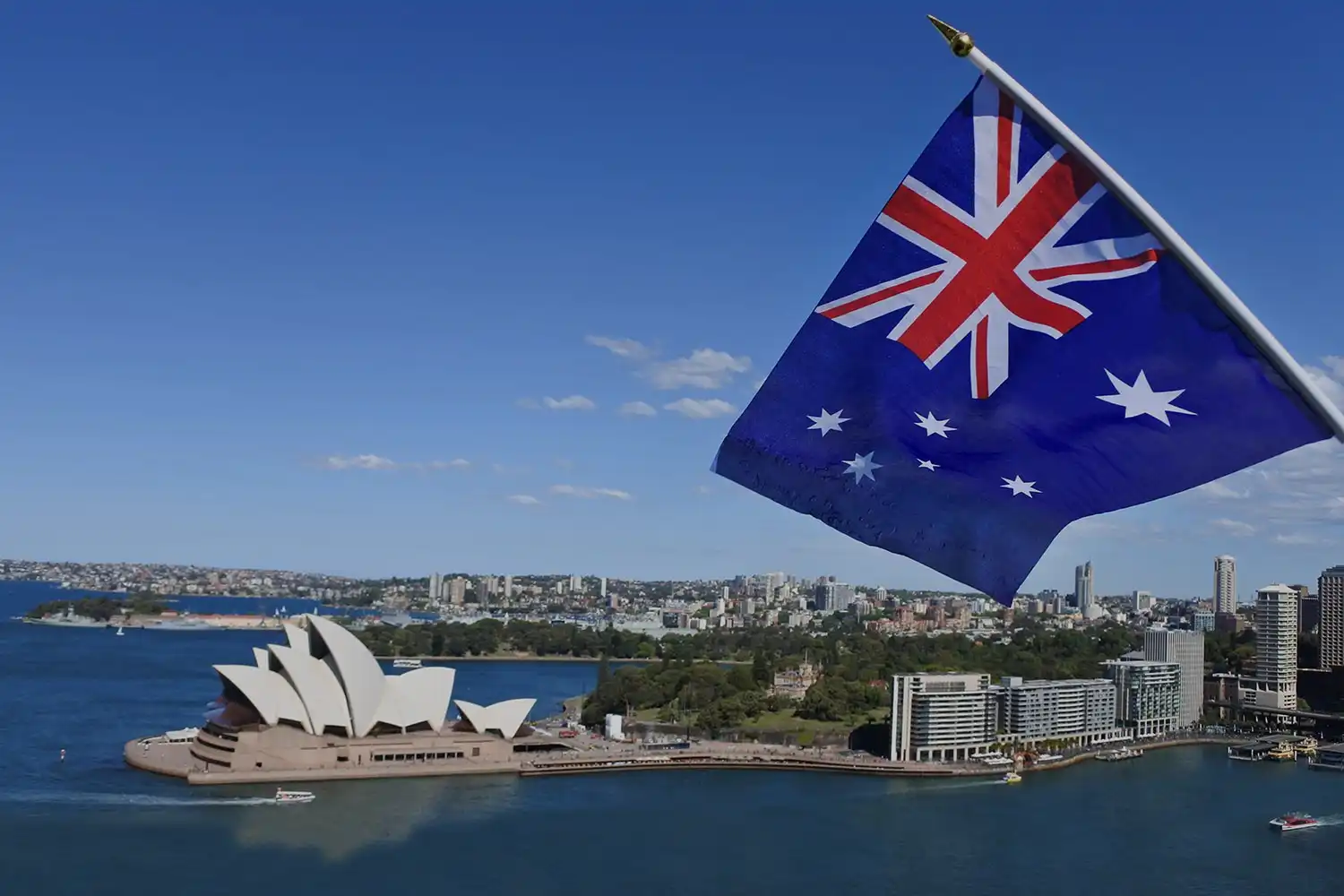 Drapeau australien flottant au-dessus de l'Opéra de Sydney avec une vue panoramique de la ville en arrière-plan