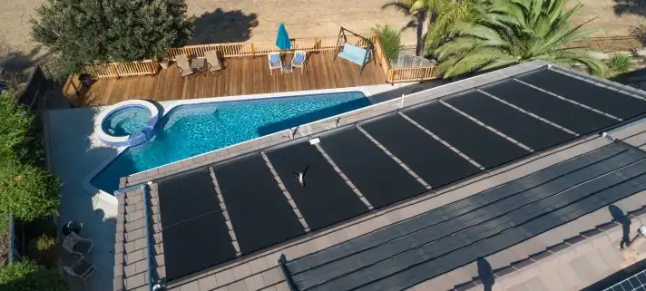 Panneaux solaires pour chauffage de piscine sur le toit d'une maison