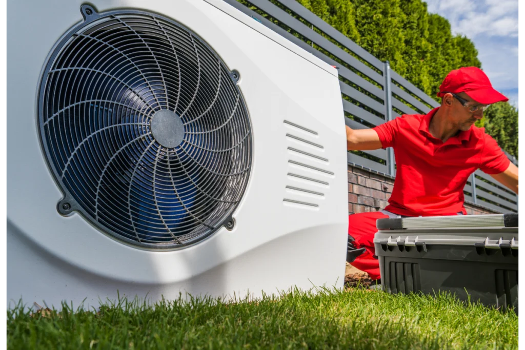 Technicien en train d'installer une unité extérieure de pompe à chaleur dans un jardin