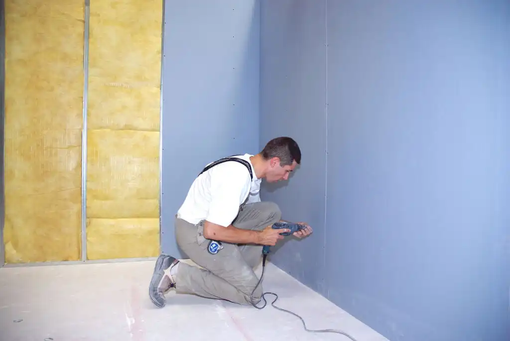 Montage de plaques d'isolation phonique sur un mur intérieur