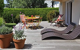 Terrasse en bois avec mobilier de jardin et plantes en pots