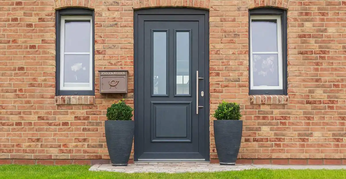 Élégante porte d'entrée bleu marine dans un mur en briques