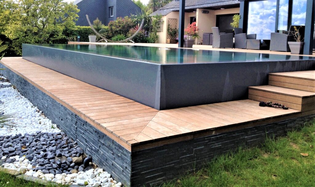 Piscine à débordement avec revêtement gris et terrasse en bois