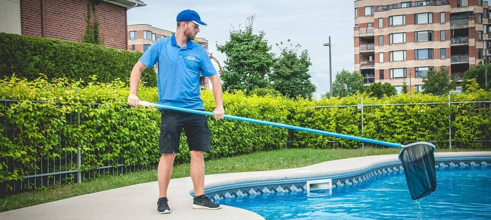 Entretien de piscine par un professionnel en tenue de travail.